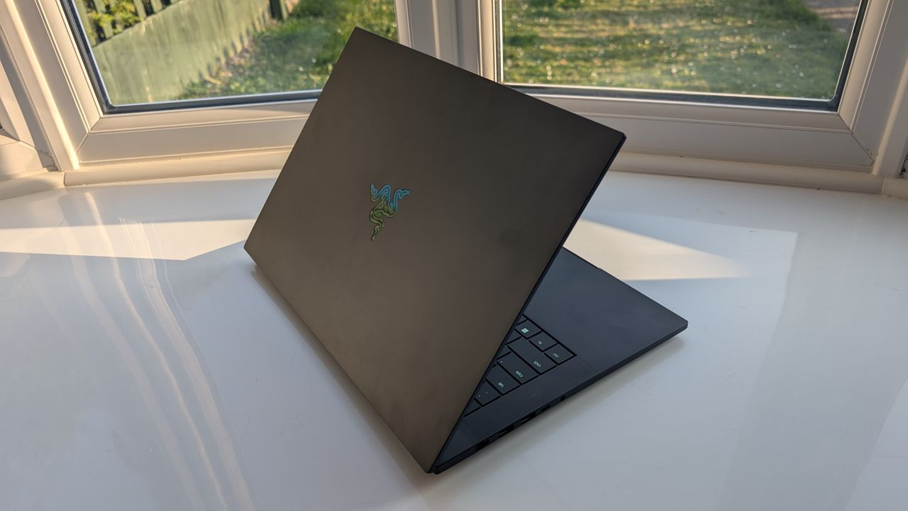 The Razer Blade 16 photographed for TechRadar on a white surface with plants in the background.