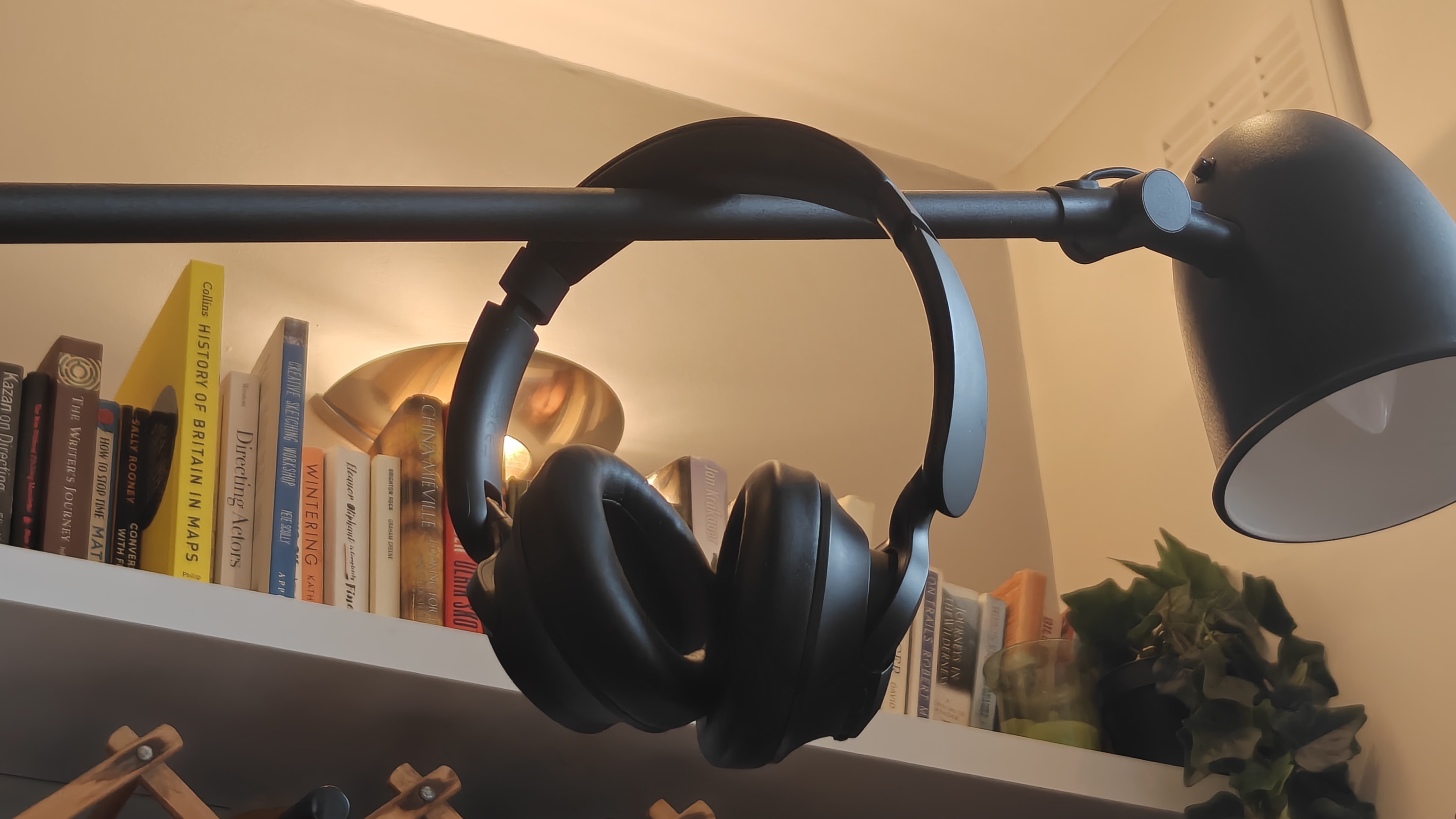 The OneOdio Focus A1 Pro a lamp, with a bookshelf in the background.