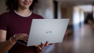 Dell XPS 13 being held in someone's hand, you can see the lid and XPS logo