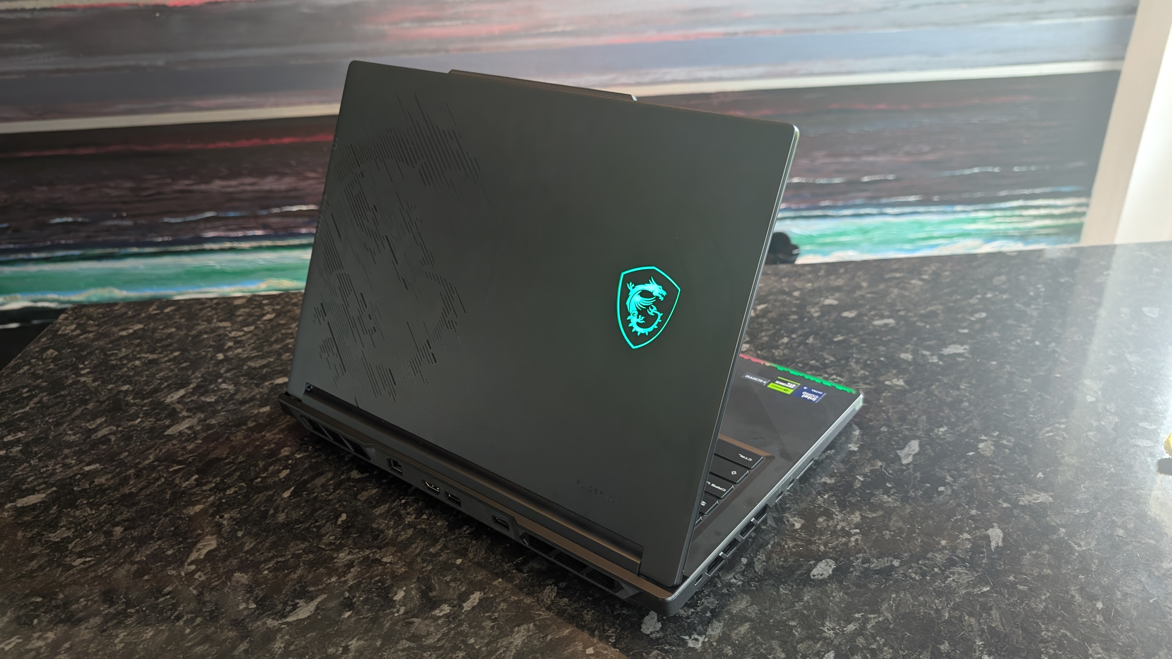 The MSI Raider 16 Max HX gaming laptop pictured on a black marble worktop.