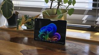 Microsoft Surface Pro 12 tablet on wooden table in relaxed cafe