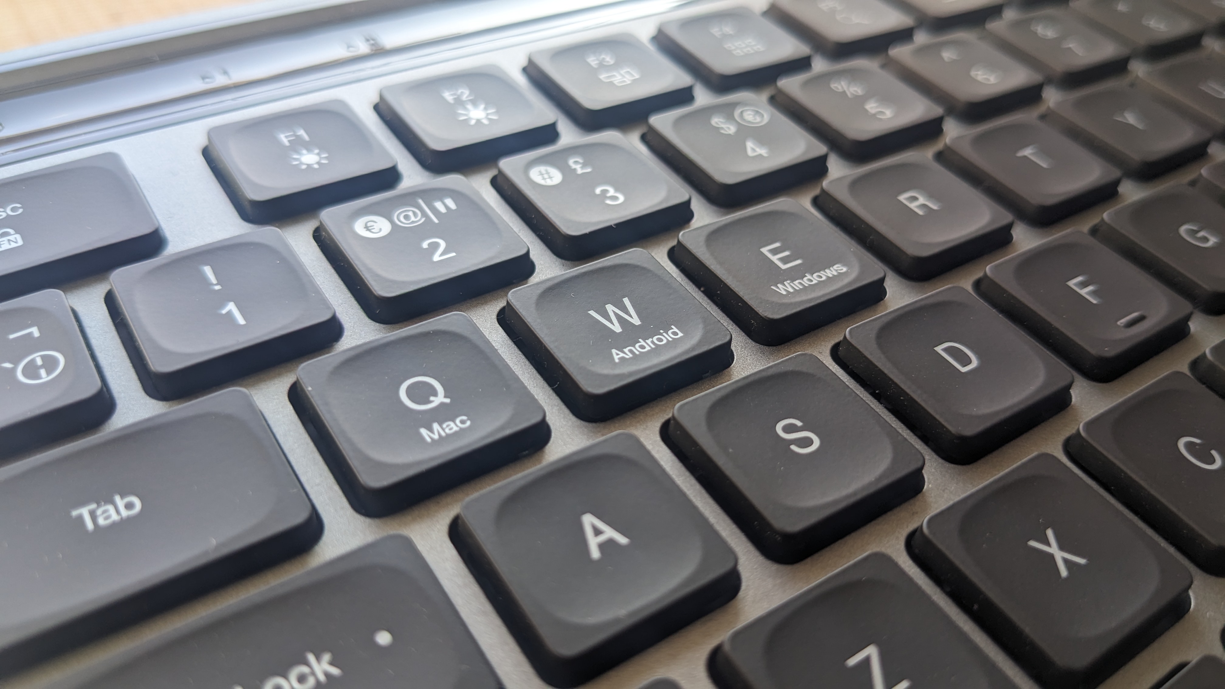 The JLab Epic Wireless Keyboard photographed on a wooden desk.