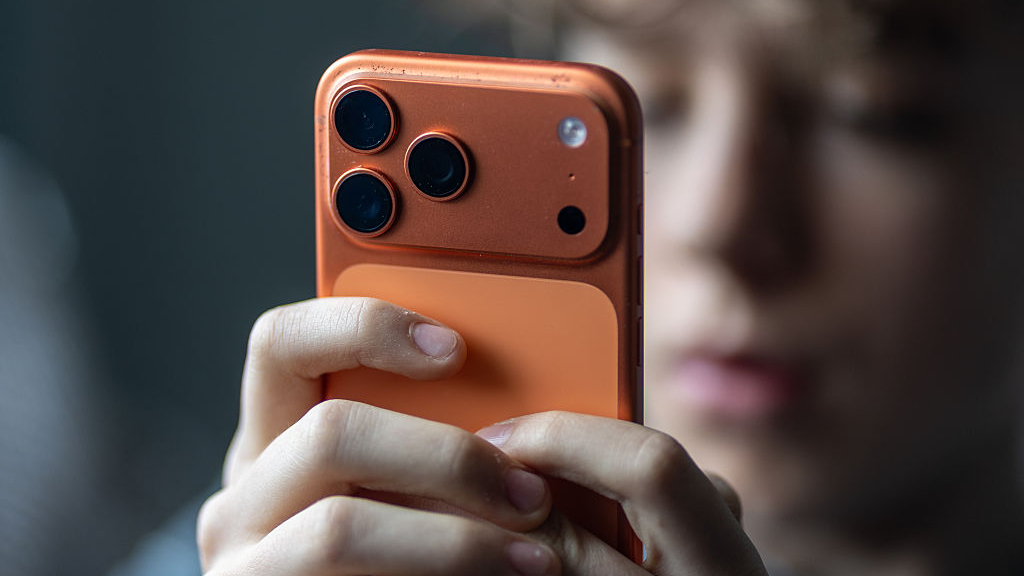 A child using an orange iPhone 17 Pro