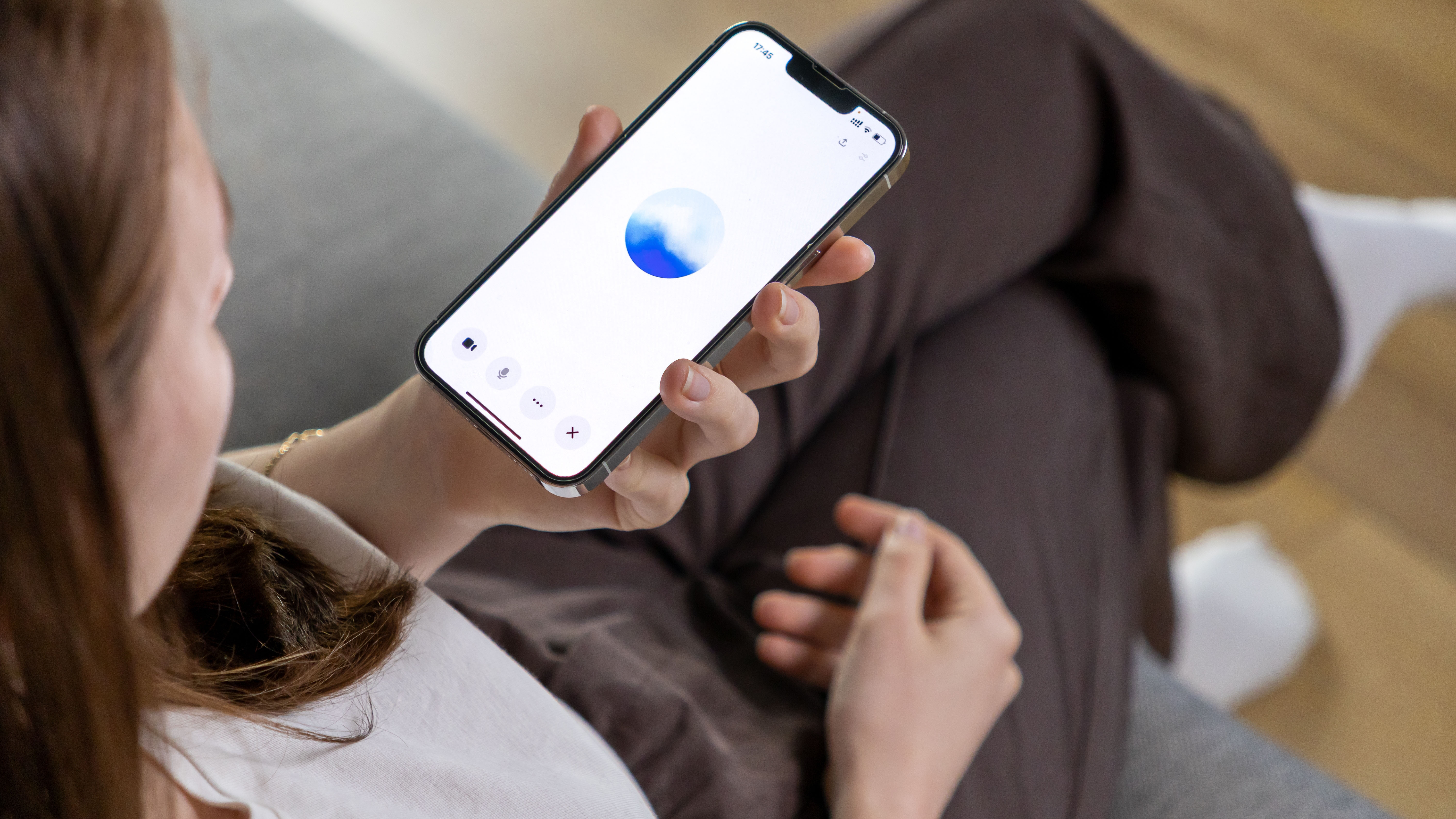 A young woman uses a smartphone to interact with a GPT-based voice.