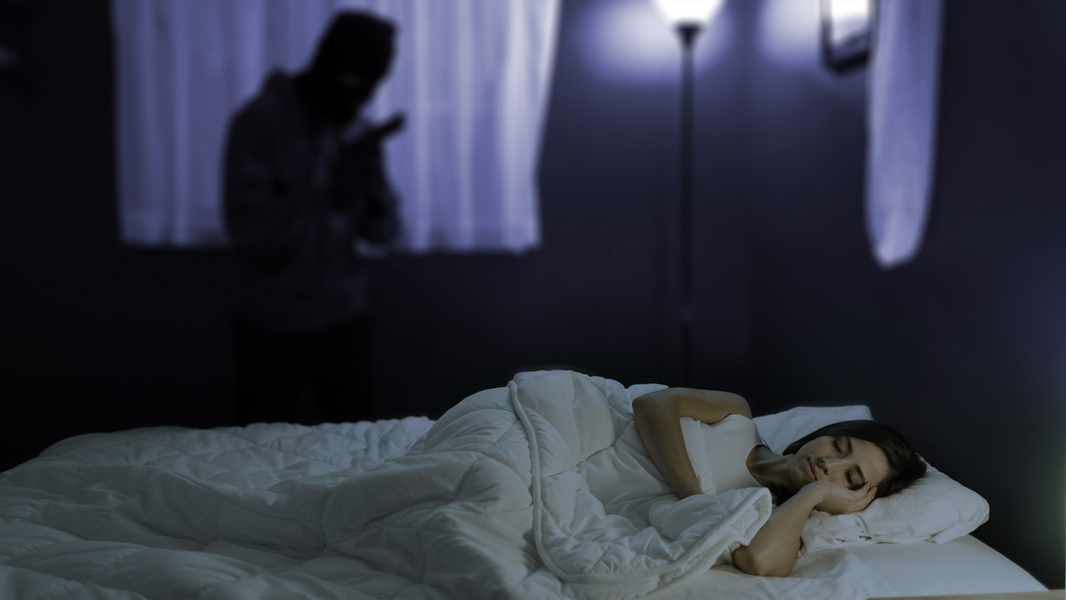 A person with sleep paralysis hallucinating an intruder in her bedroom
