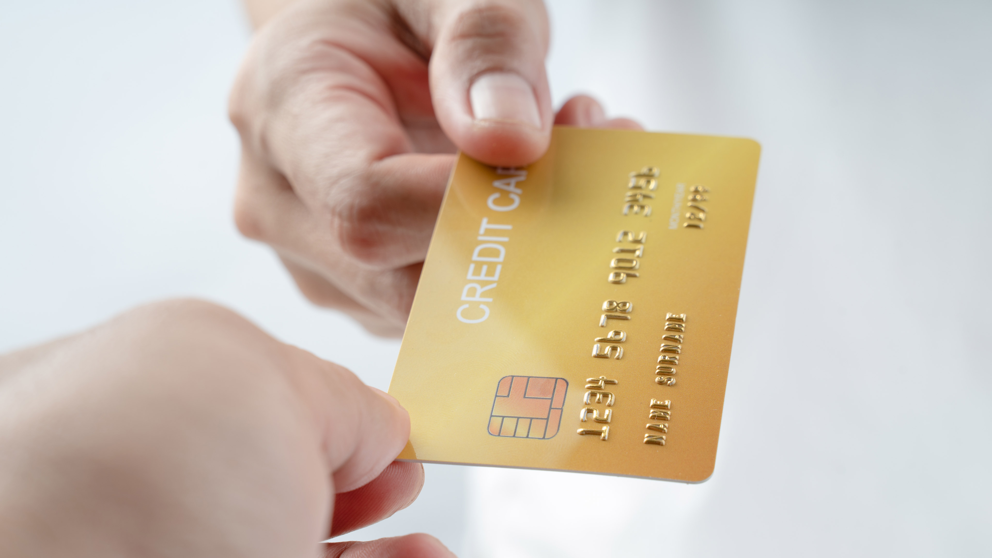 A credit card passed between two hands