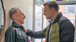 David Morrissey pushes Alan Cumming against a hallway wall