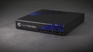 Kaleidescape Strato E Movie Player. It's a black rectangular device with blue highlighting, photographed atop a grey surface