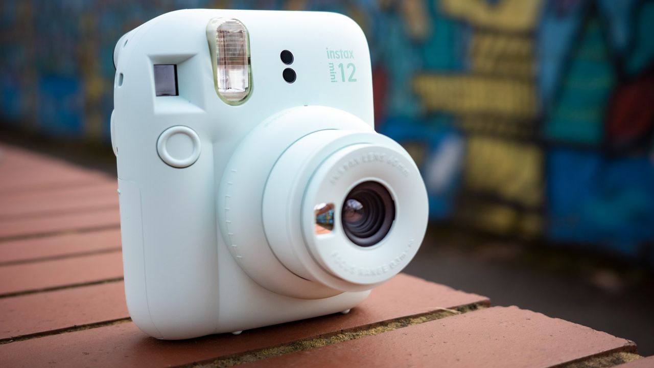 Instax Mini 12 on a brick wall in front of graffiti