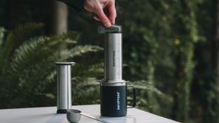 Person using AeroPress Steel to make coffee outdoors