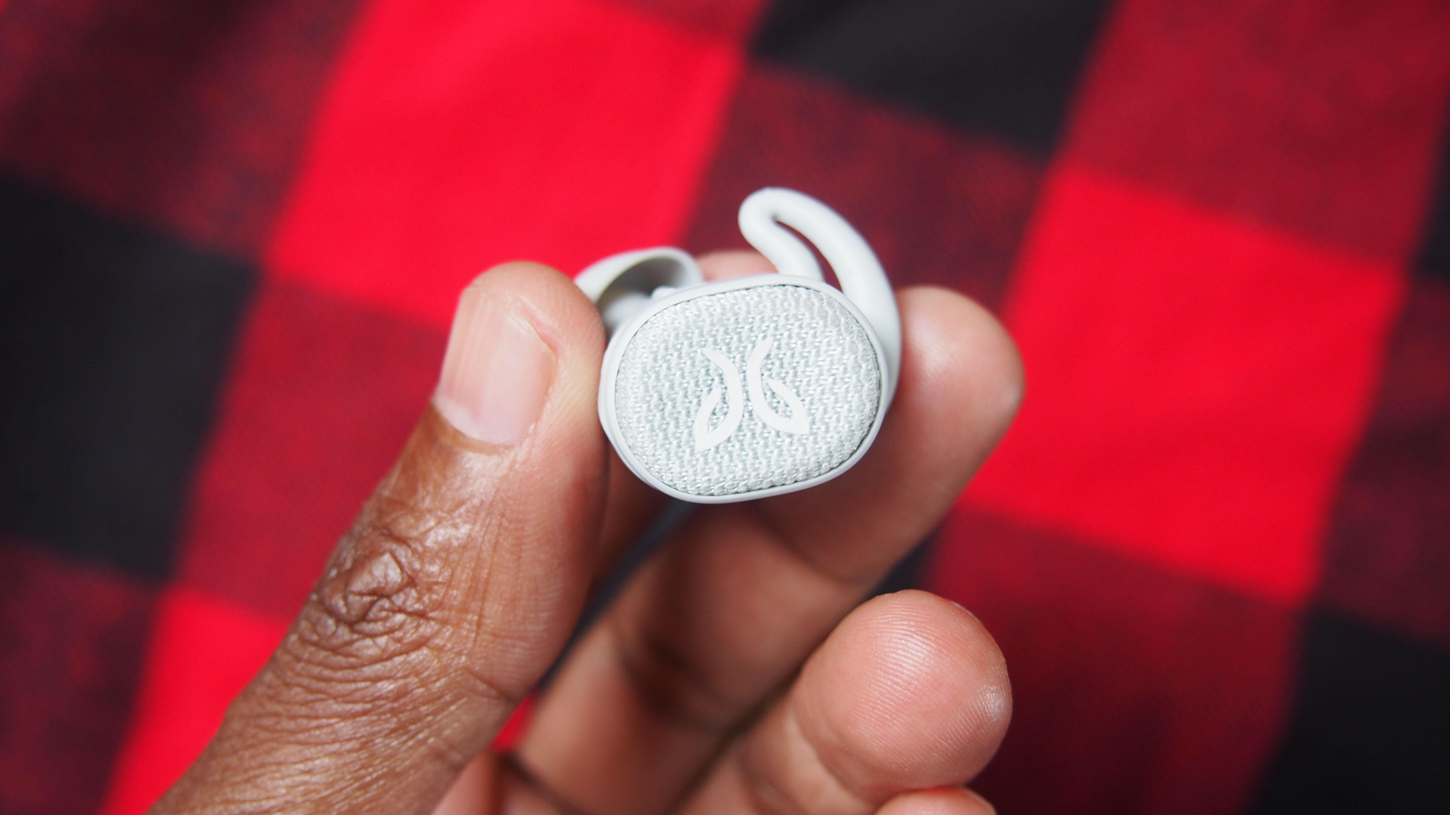 Someone holding one of the jaybird vista 2 wireless earbuds between their thumb and forefinger