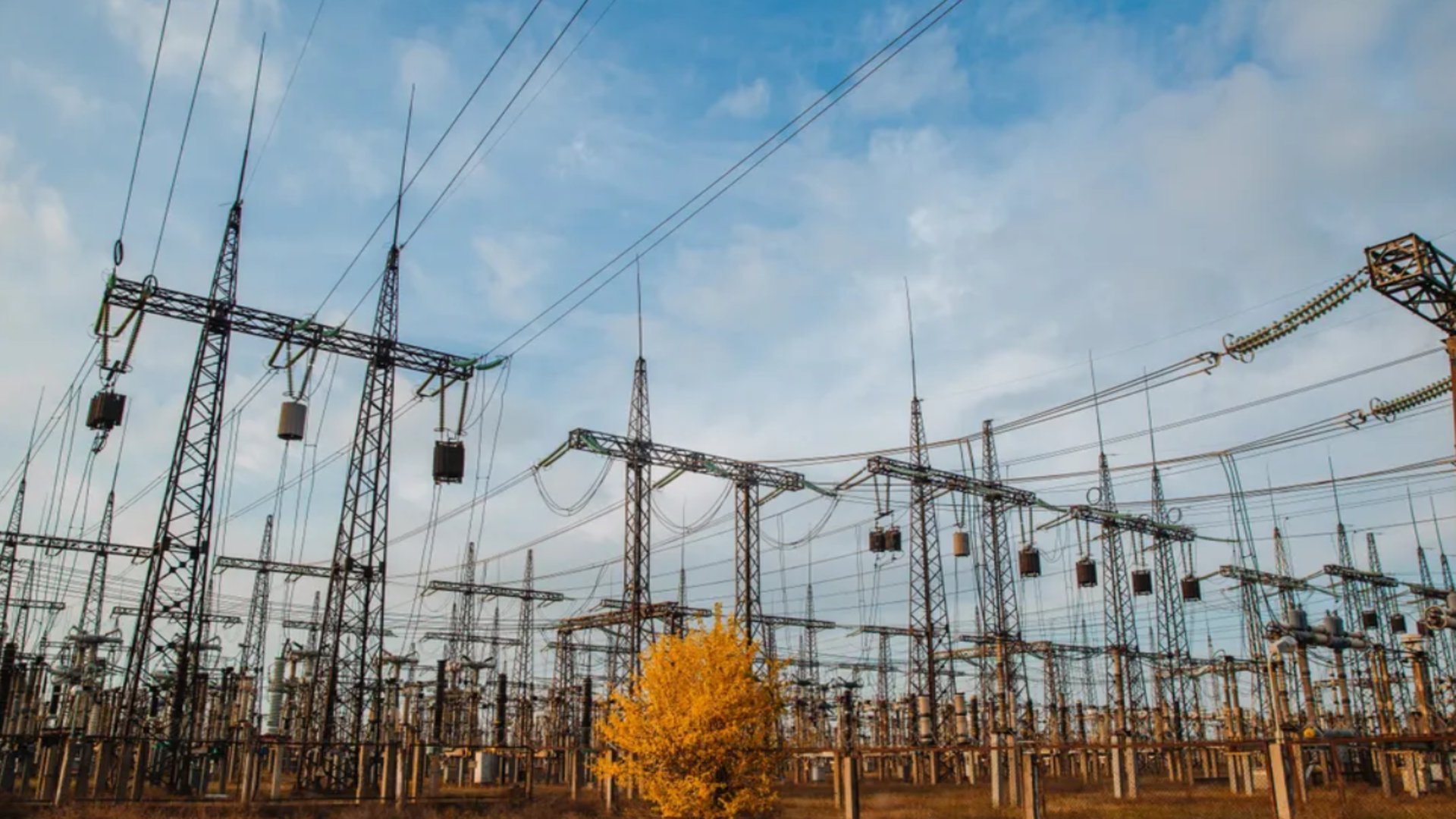 Electrical pylons and high voltage power lines are behind a barbed wire fence. critical infrastructure