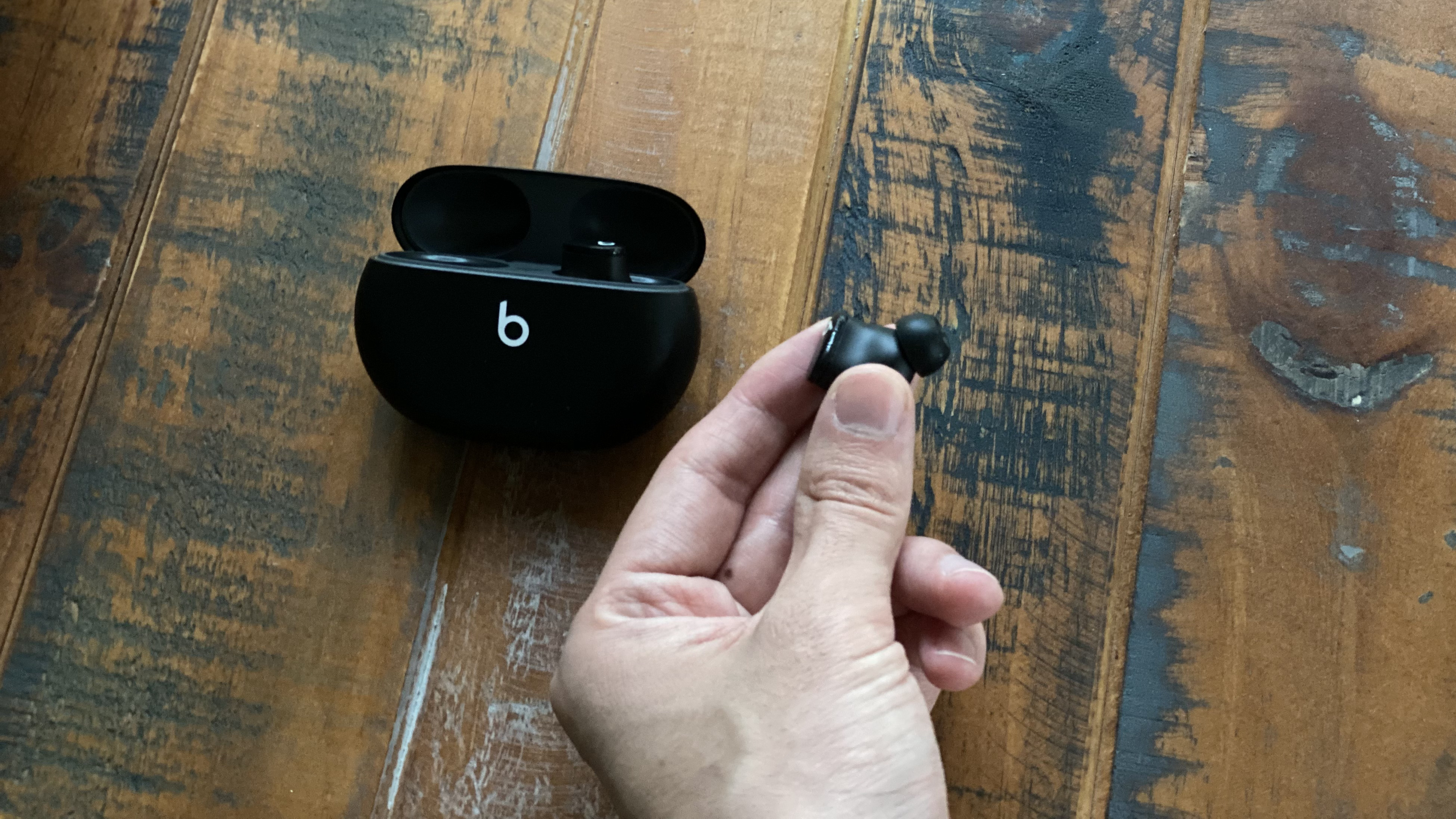 Beats Studio Buds on a wooden table