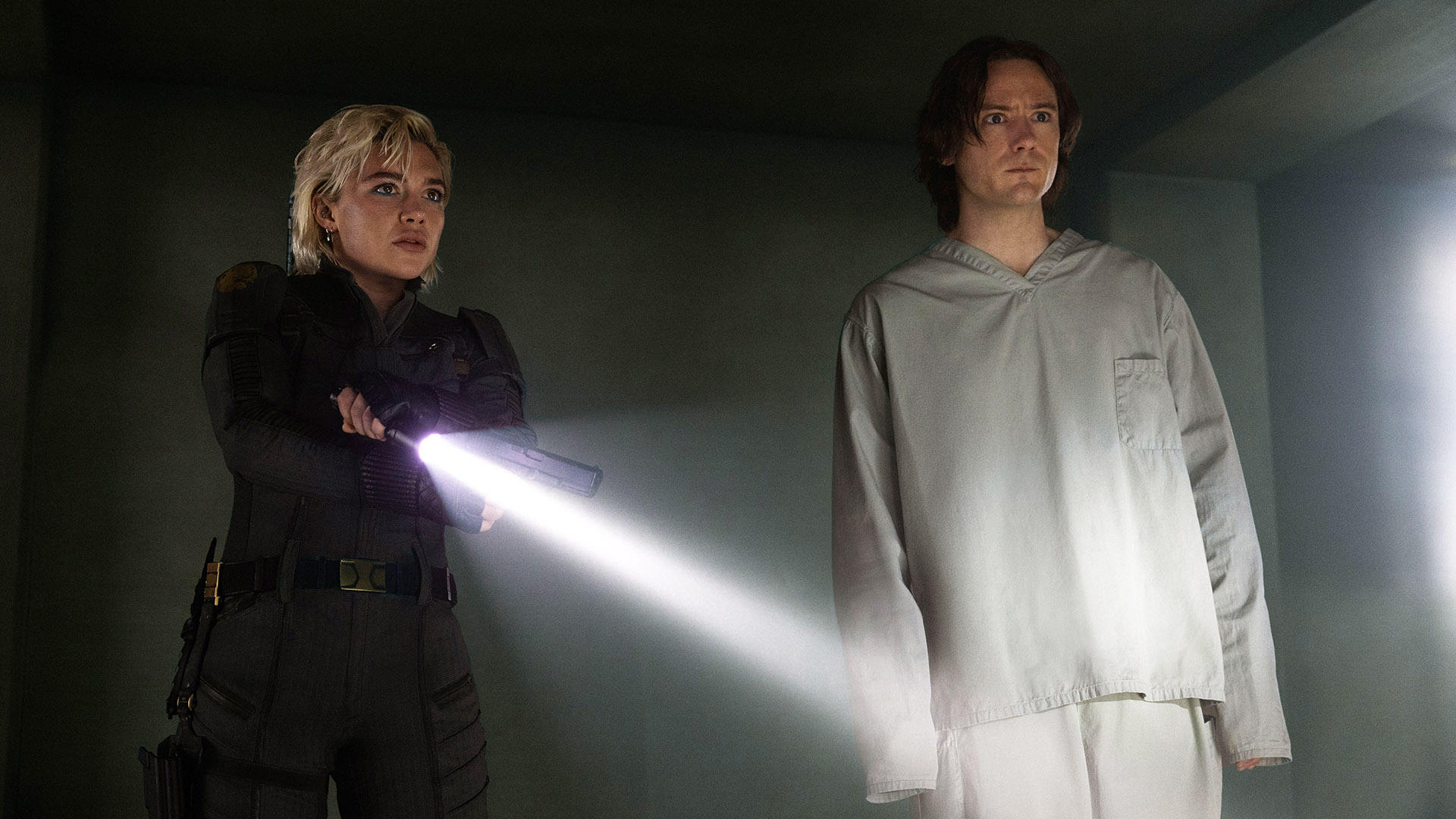Yelena holding a gun and flashlight while Bob stands next to her in Marvel's Thunderbolts* film