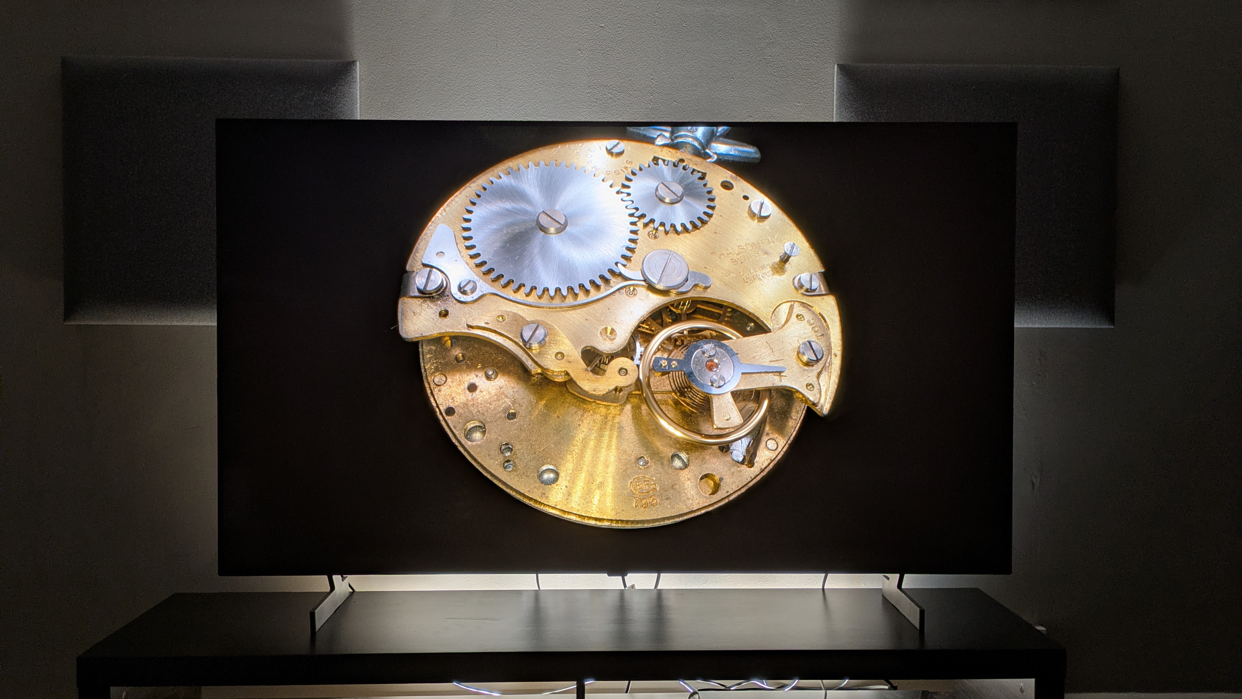 LG B6 OLED TV with a gold stopwatch on screen. The image shows the B6's highlights with the gold of the watch and the deep black tones of the background