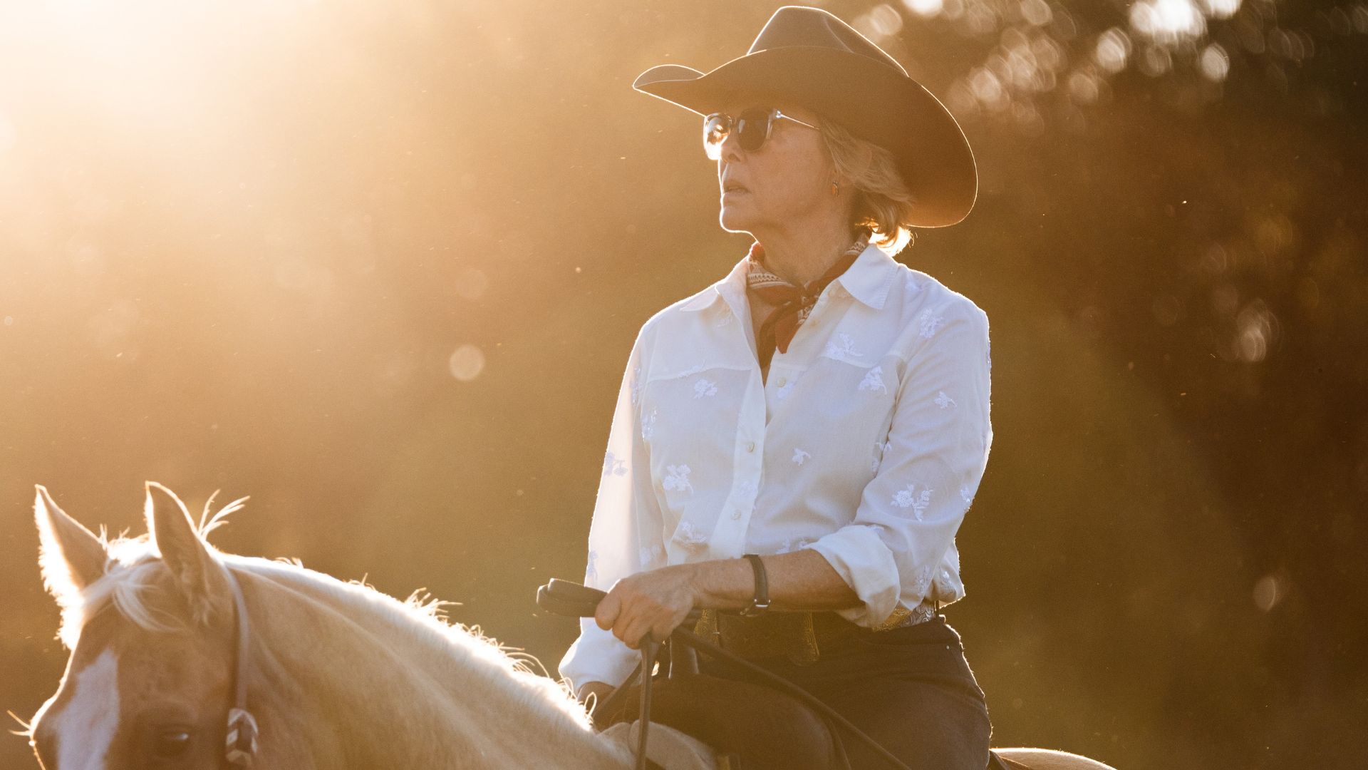 Annette Bening rides a horse 