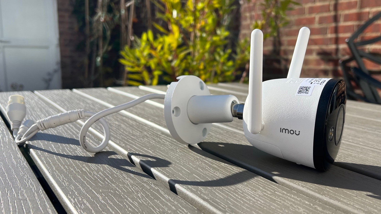The side view of the Imou Bullet 2 on a garden table