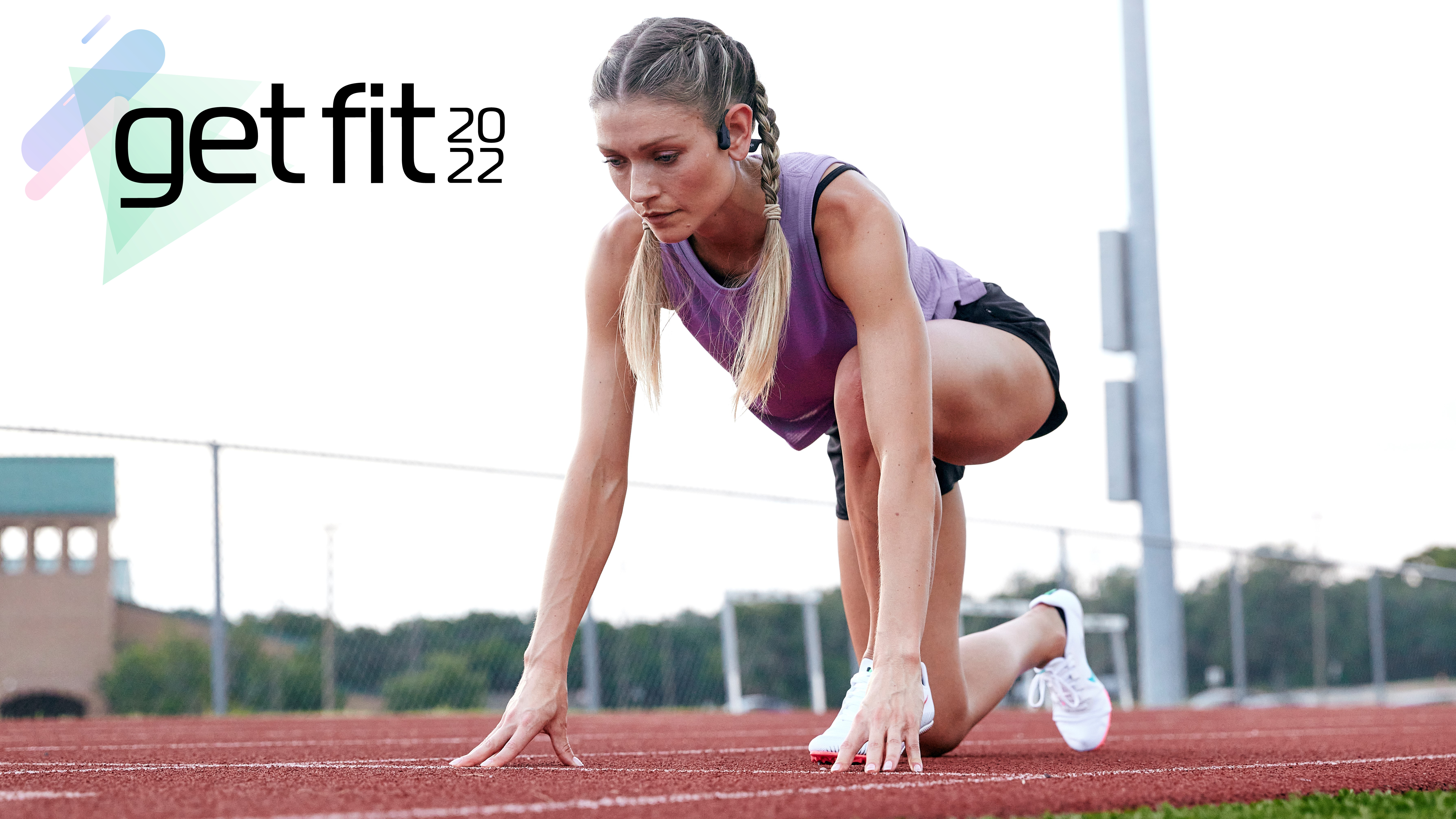 Woman on race track wearing Shokz OpenRun Pro headphones