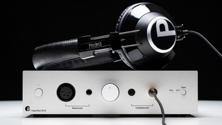 Pro-Ject Head Box S3 in silver against a black background with a pair of headphones on top