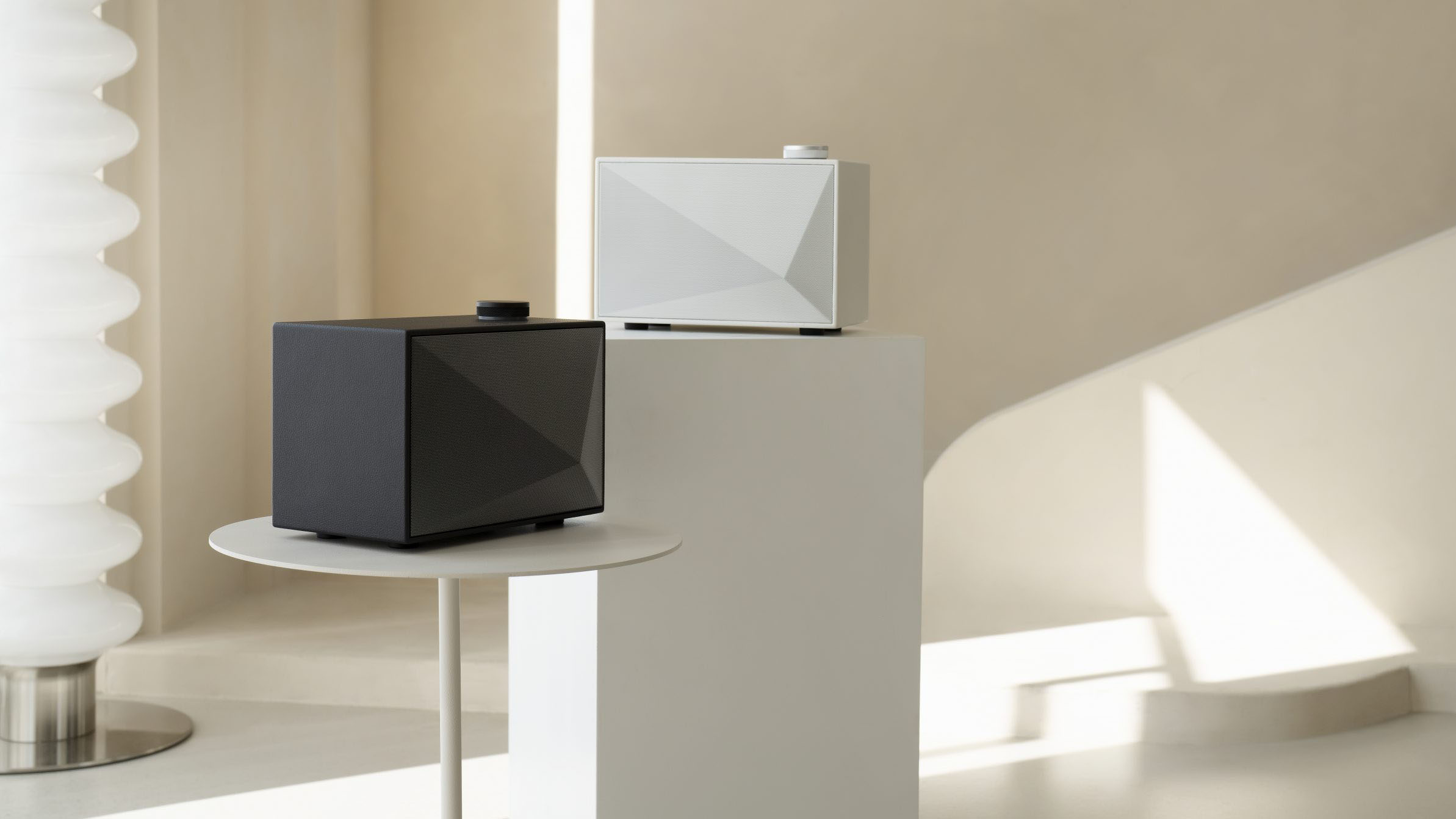 two wireless speakers in black and white