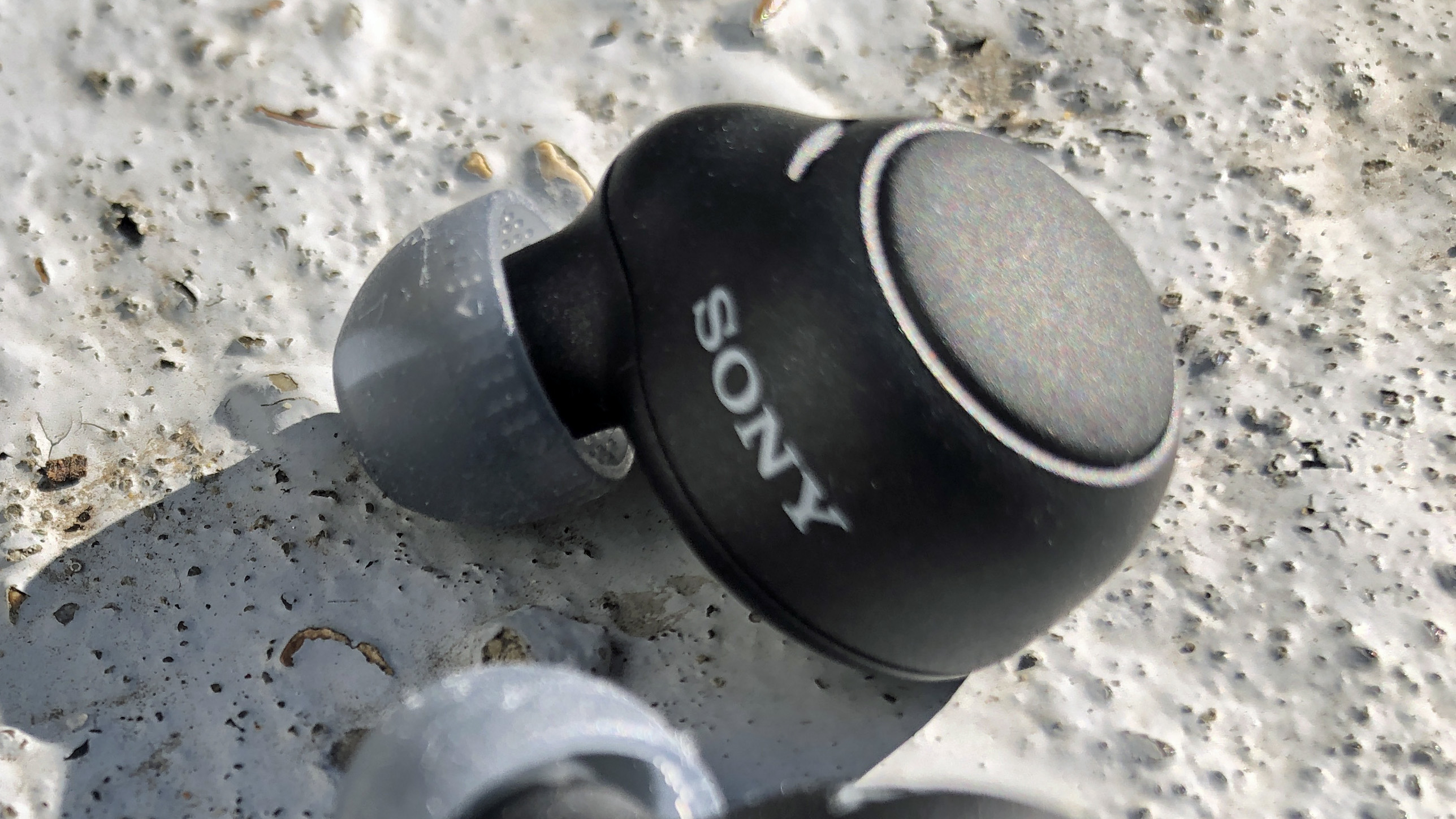 A closeup of one sony wf-c500 earbud