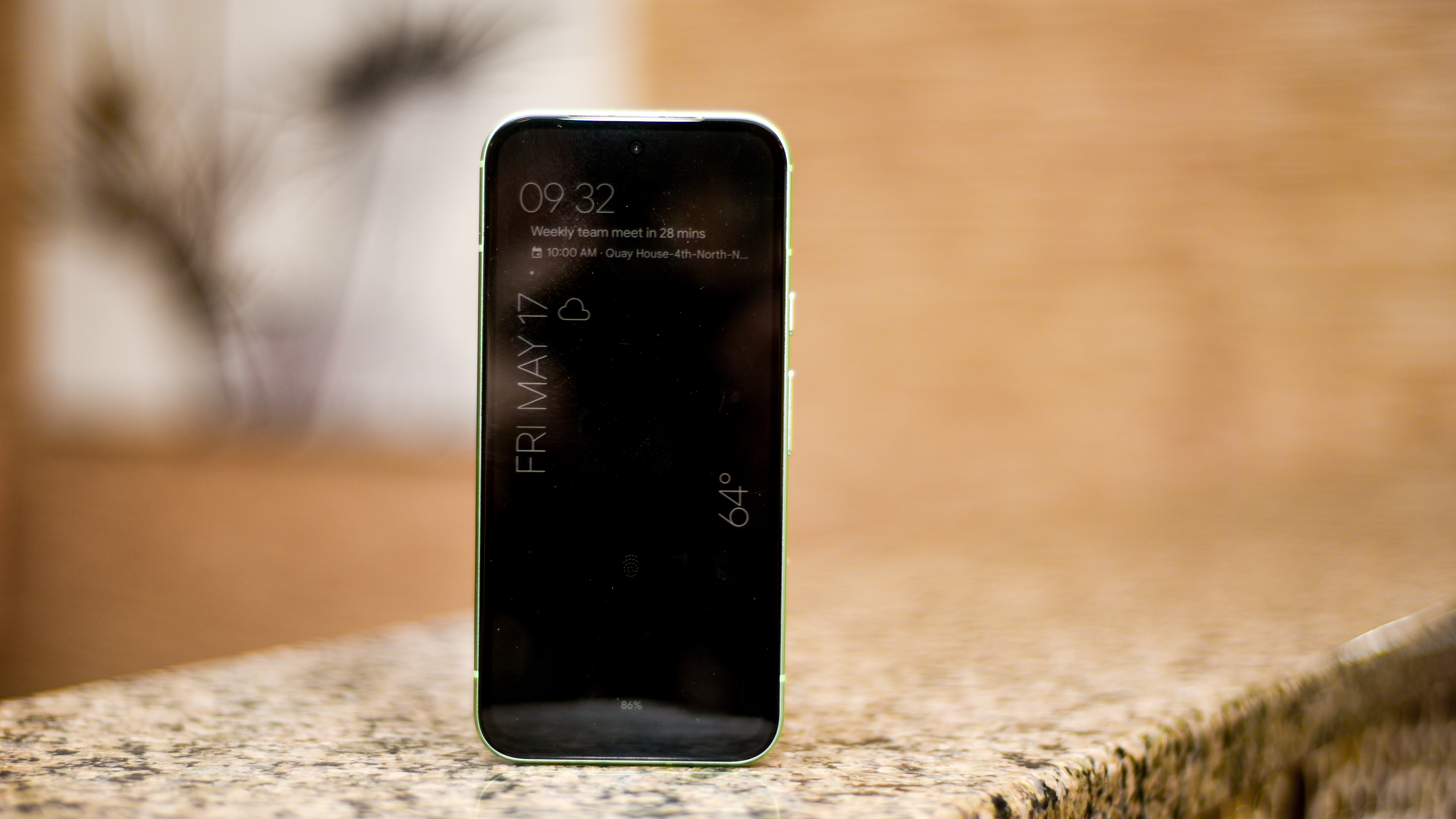 Google Pixel 8a in aloe green showing lock screen always-on display