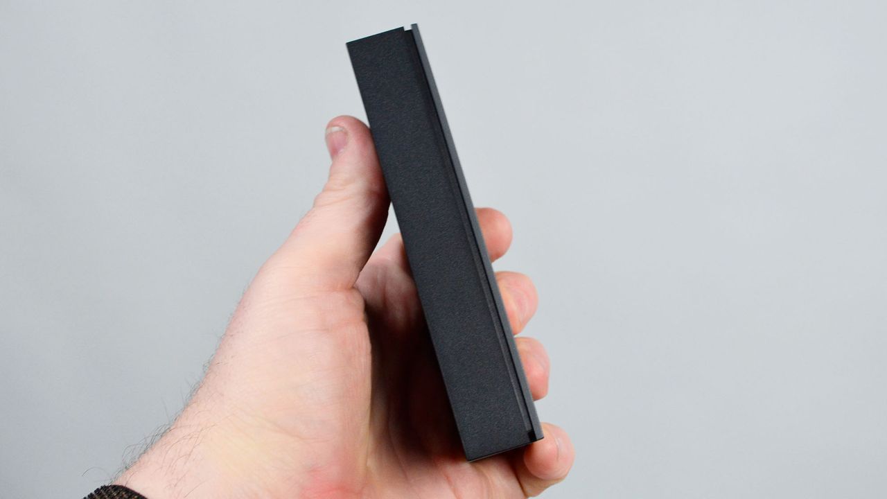 A masculine hand holding a Seagate FireCuda external gaming hard drive