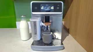 Philips Caf&eacute; Aromis coffee maker on kitchen counter with bottle of oat milk