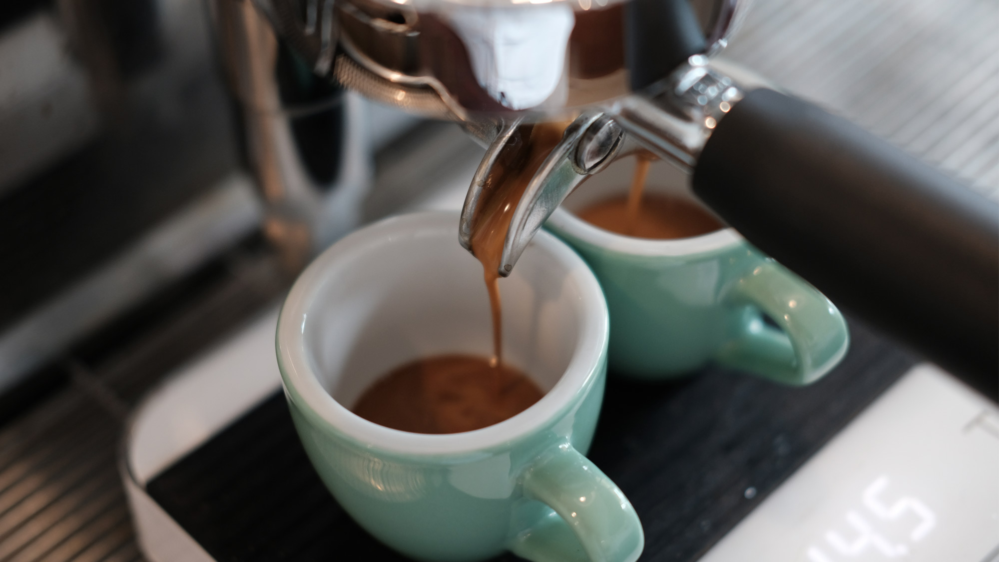 Two shots of espresso being poured from machine