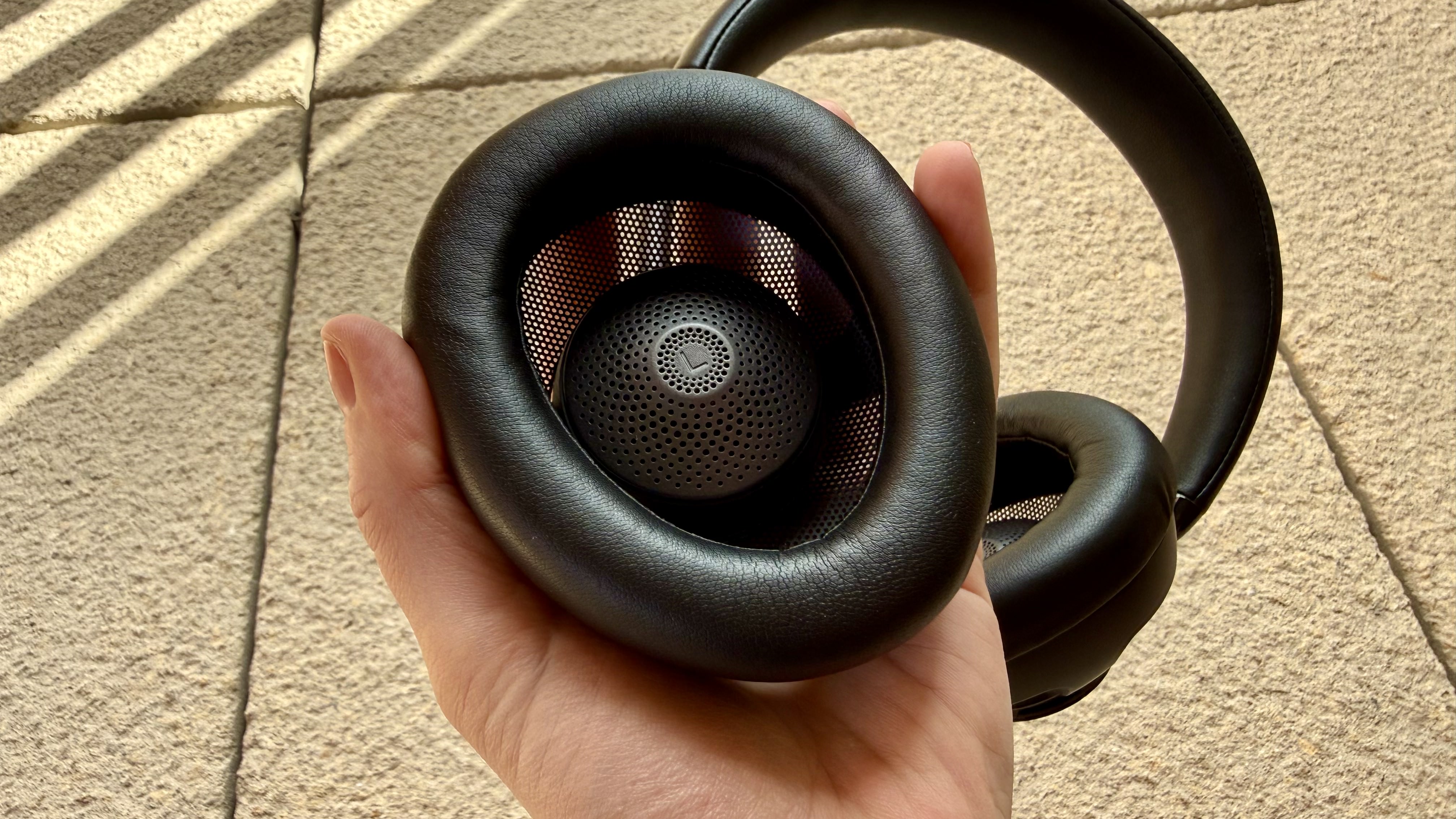 The jlab jbuds open wireless headphones pictured on a stone surface
