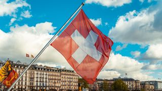 Swiss flag with view of Geneva city, Switzerland