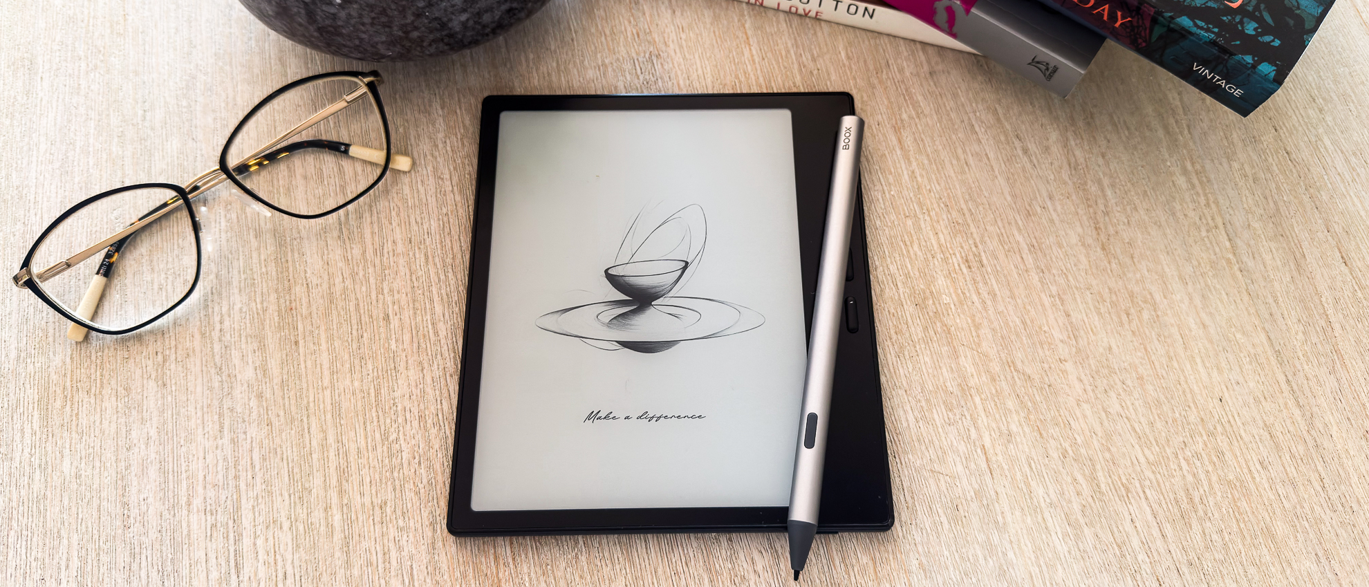 The Boox Go 7 ereader with the InkSense Plus stylus on a tablet beside a pair of spectacles