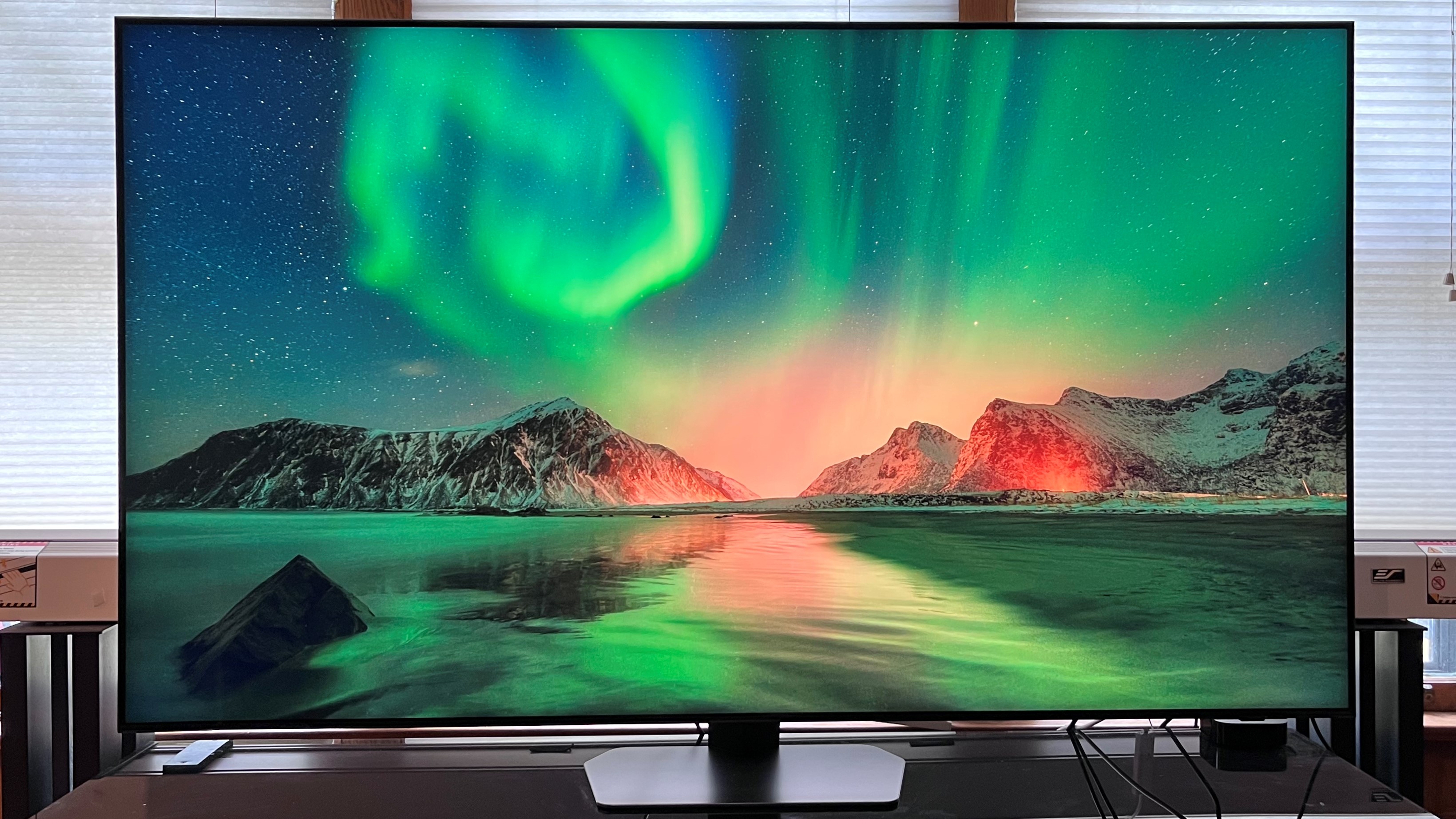 The Samsung QN90C OLED TV displaying a green landscape of the northern lights.