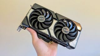 The Asus Dual OC RTX 5060 being held by a person's left hand.