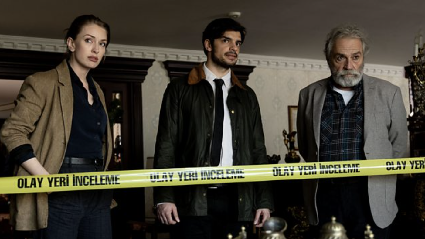 Ayşe Farsakoğlu (Yasemin Kay Allen), Mehmet Suleyman (Ethan Kai) and &Ccedil;etin Ikmen (Haluk Bilginer) stand behind yellow police tape in The Turkish Detective