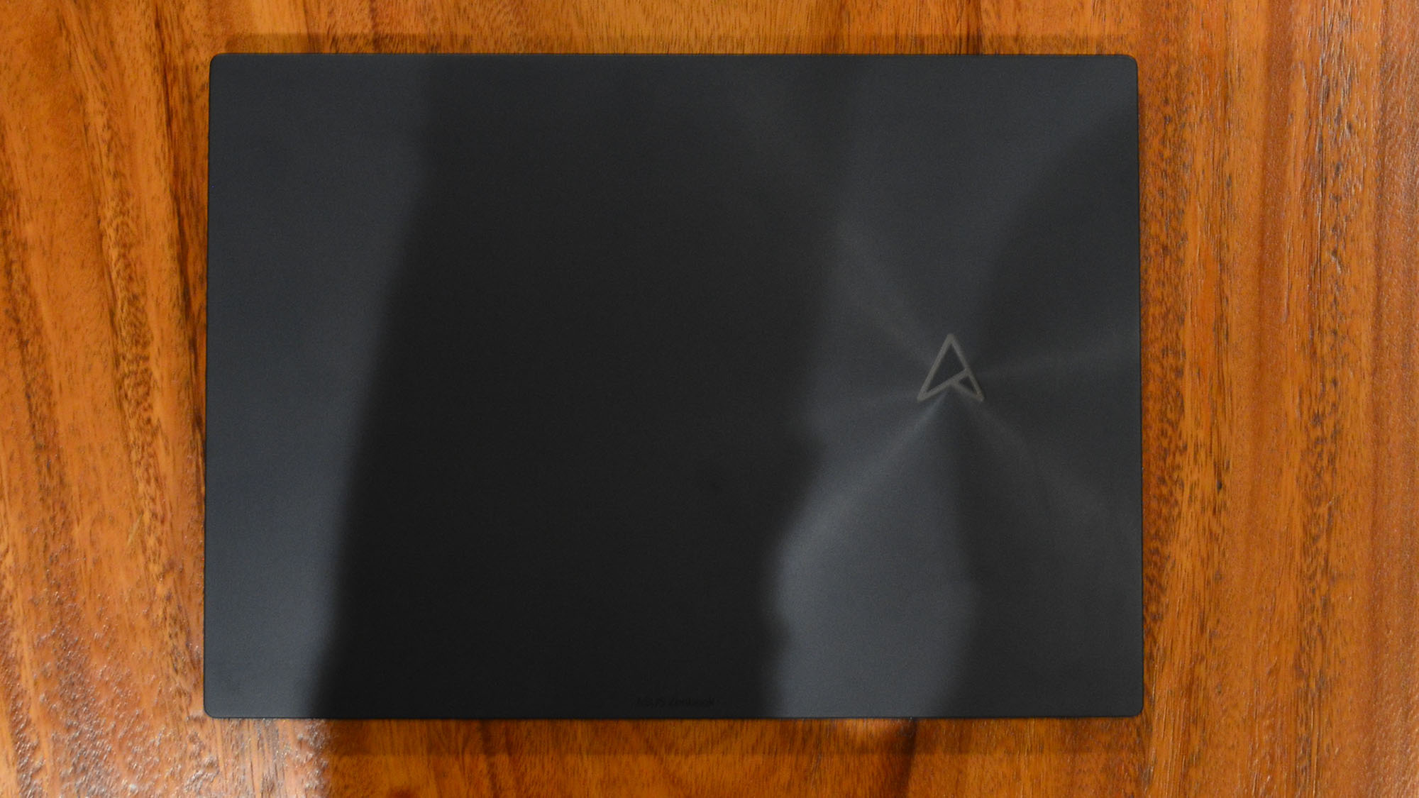 An Asus Zenbook Pro 16X OLED on a wooden table