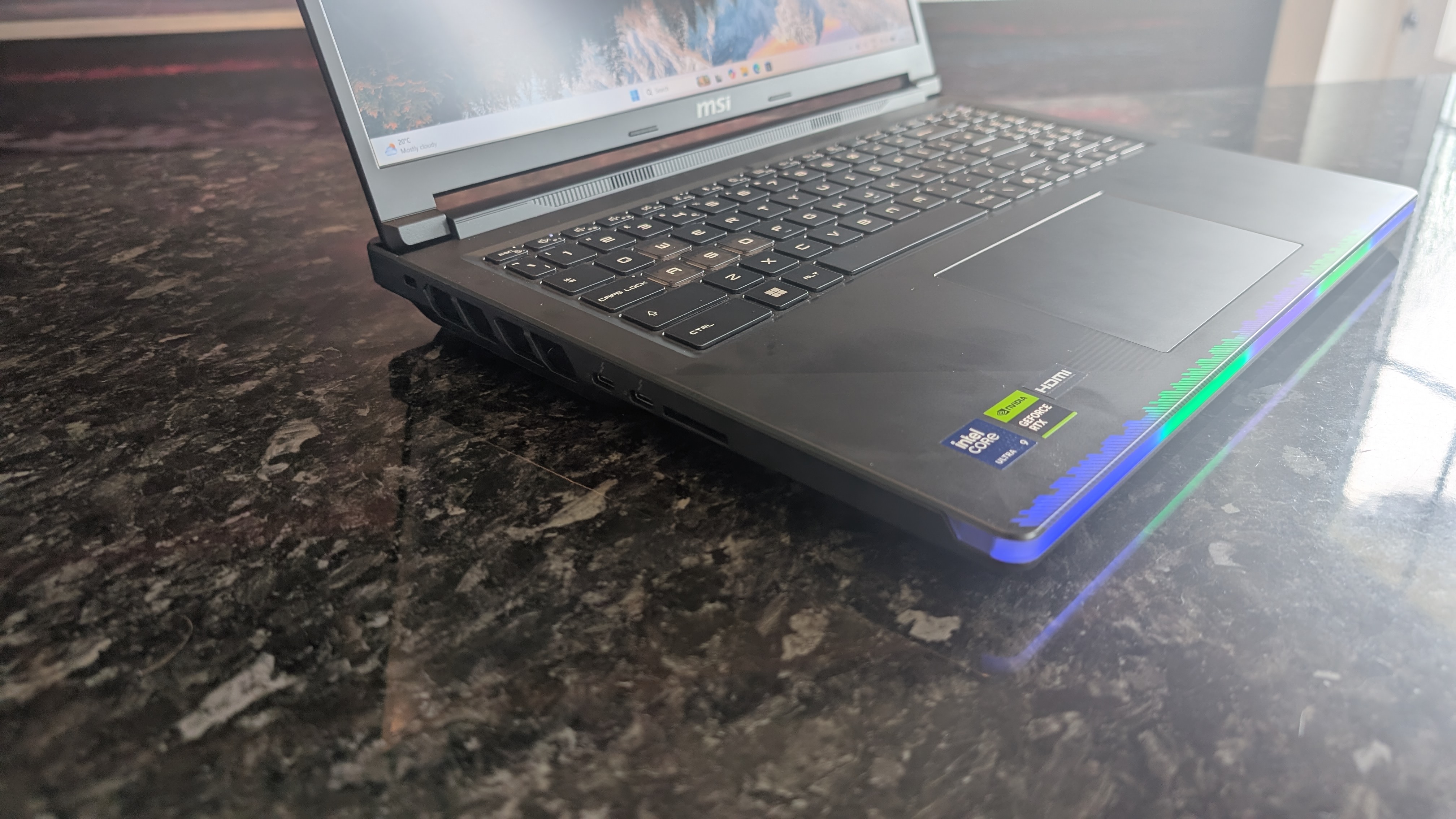 The MSI Raider 16 Max HX gaming laptop pictured on a black marble worktop.