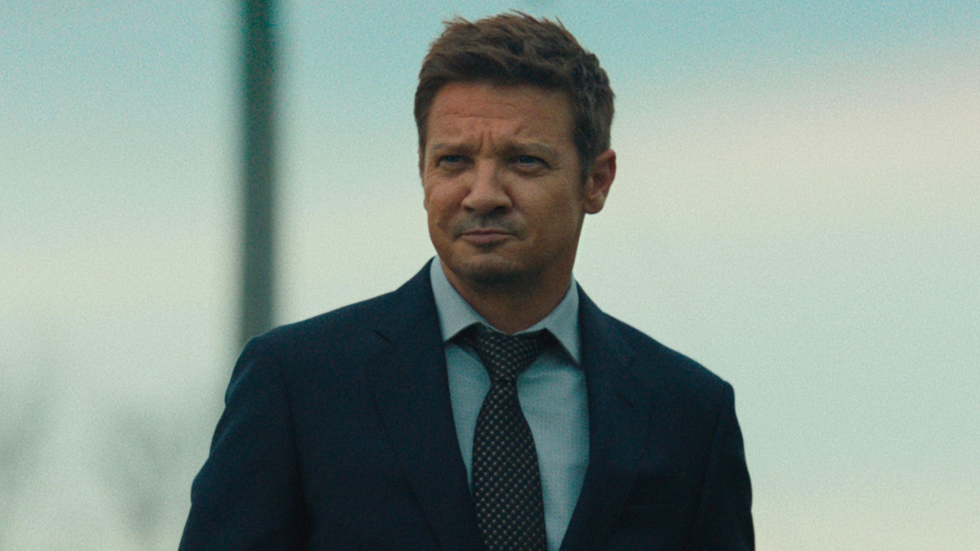 Jeremy Renner looks at something offscreen