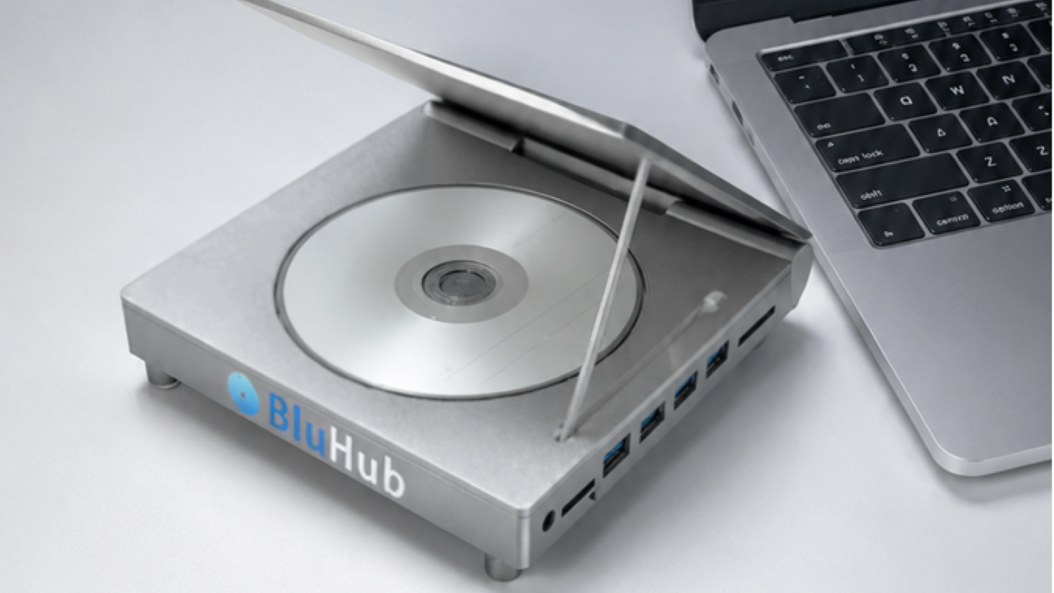 The BluHub USB hub and disc drive next to a Mac laptop