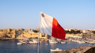 Maltese flag flying over marina