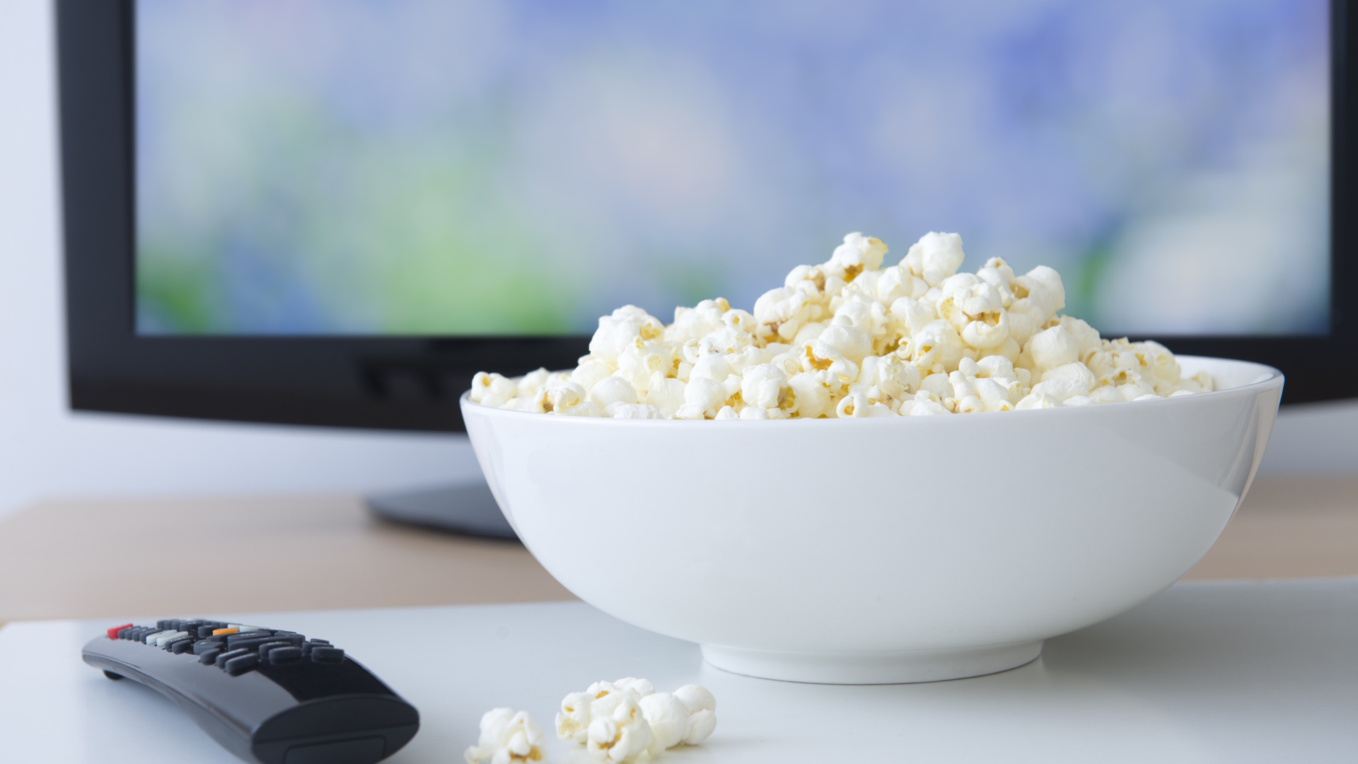 Television set and bowl of popcorn.