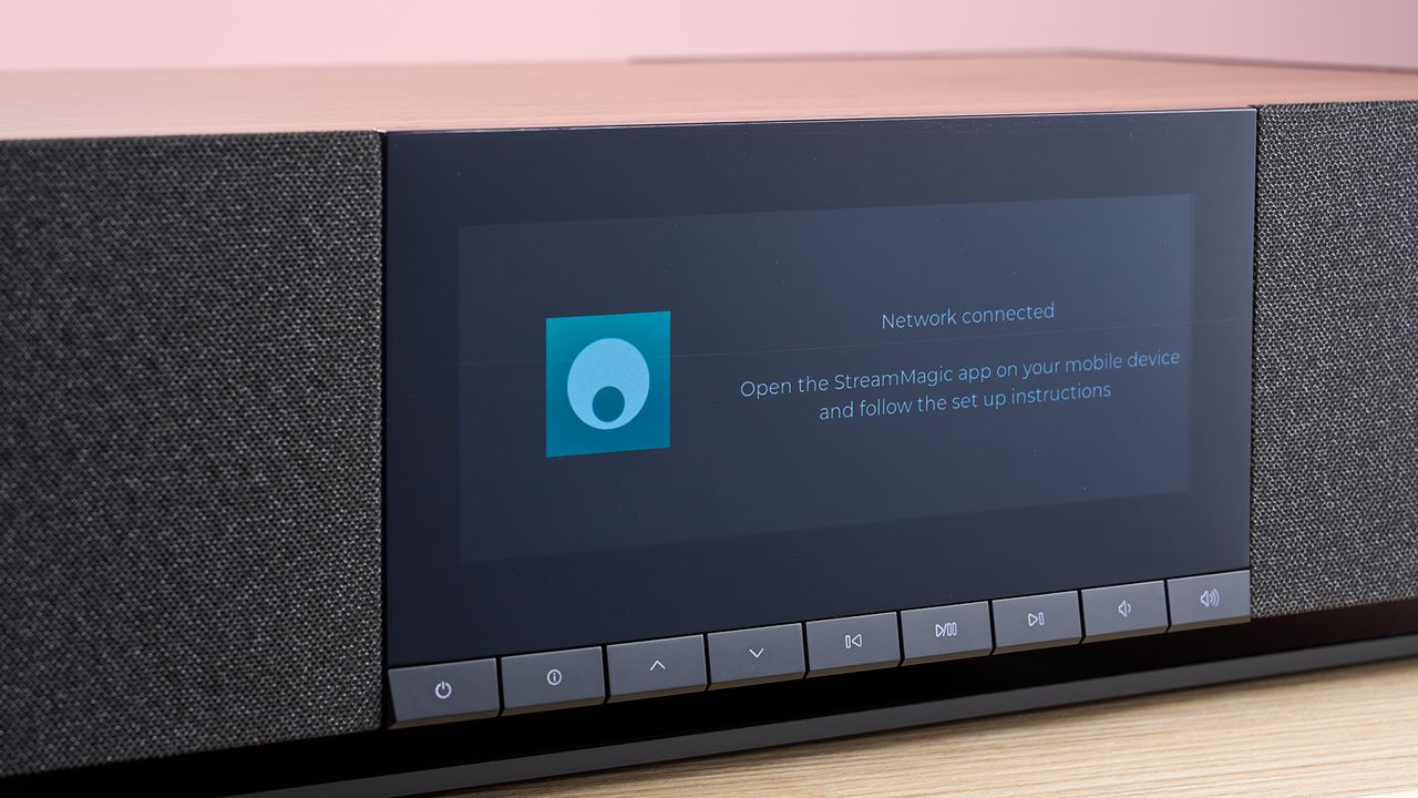 A closeup of the Cambridge Audio Evo One's screen, which says that the network is connected and ready to play music. Below the screen are some small buttons for playback and connectivity.