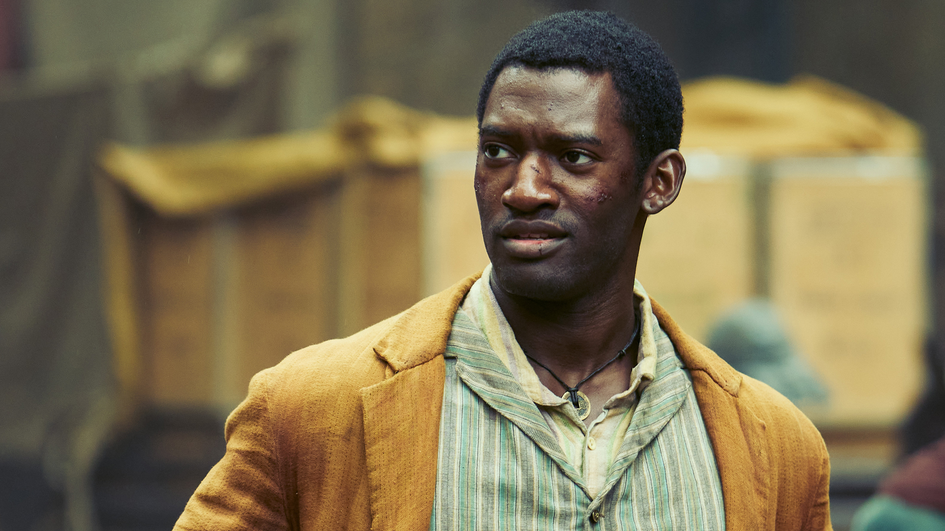 A close up of Hezekiah wearing a dusty yellow coat in A Thousand Blows on Disney Plus