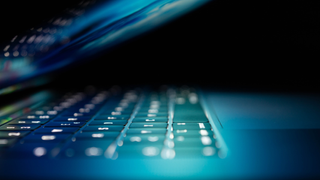 Laptop in darkness with half-closed lid