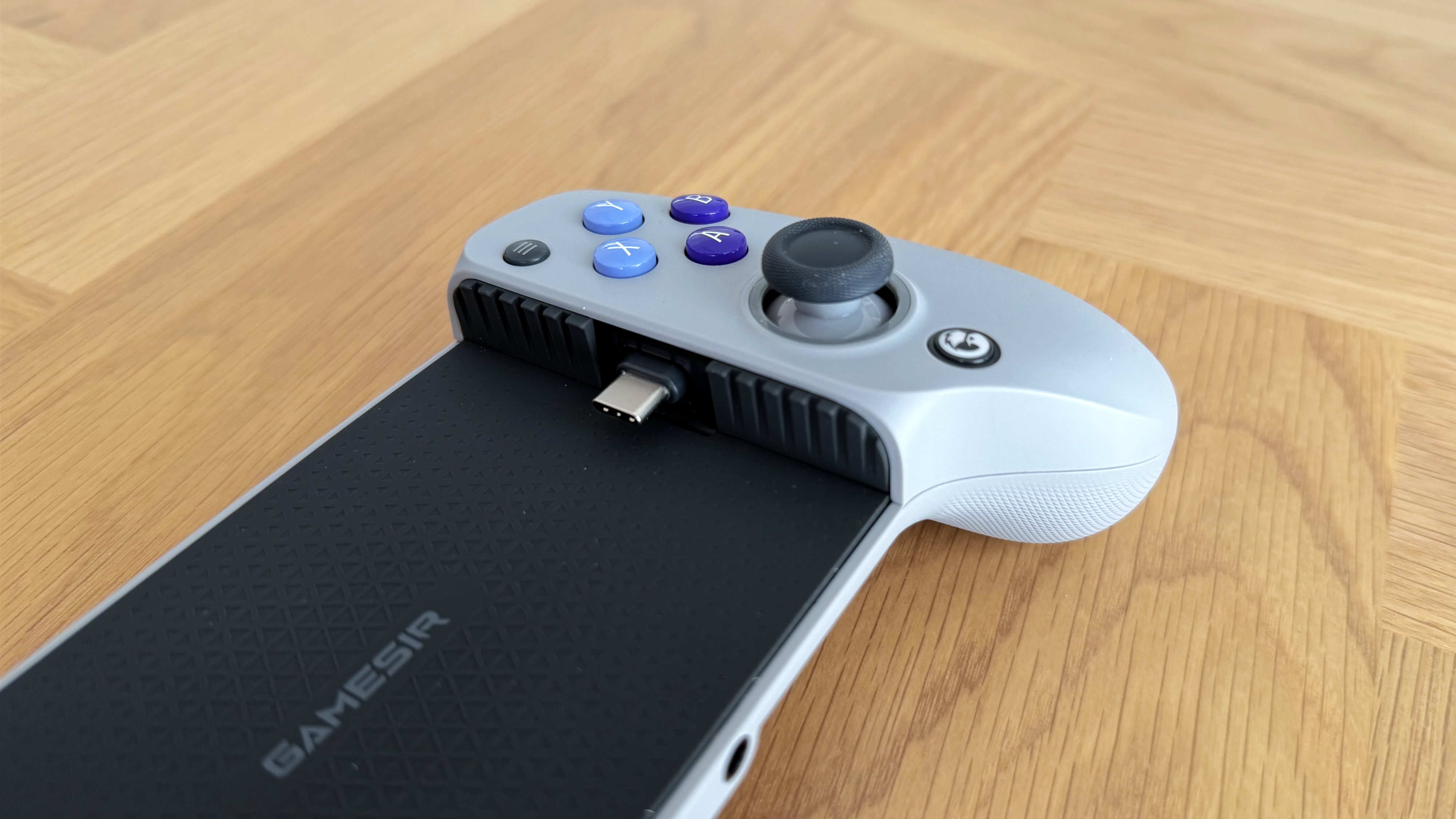 The GameSir G8 Galileo mobile gaming controller on a wooden surface.