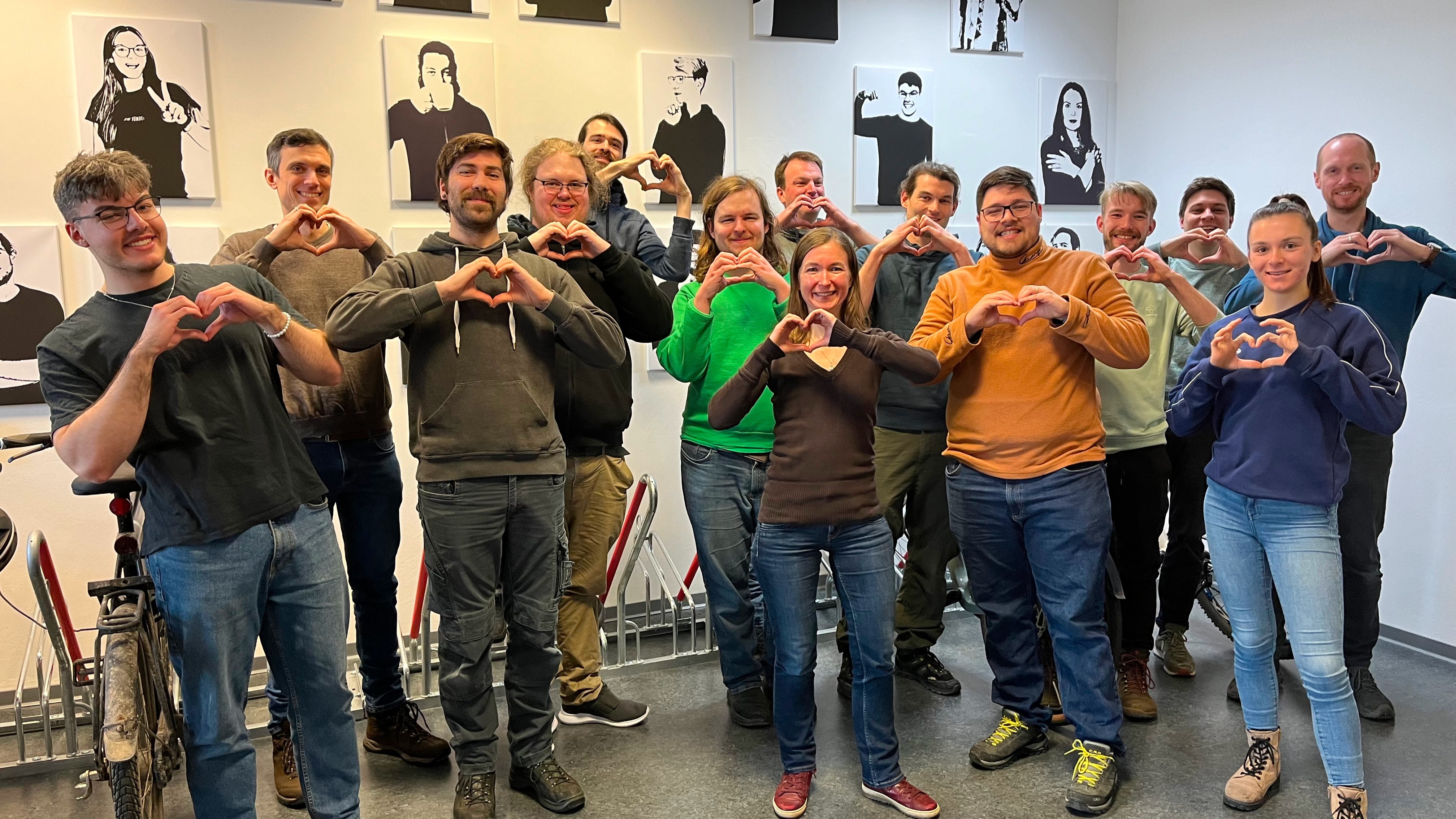 Tuta's team making hearts symbols with their hands