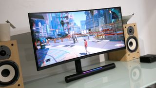 Huawei MateView GT on a glass desk fringed by two speakers