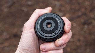 Viltrox AF 28mm f/4.5 body cap lens in photographer's hand