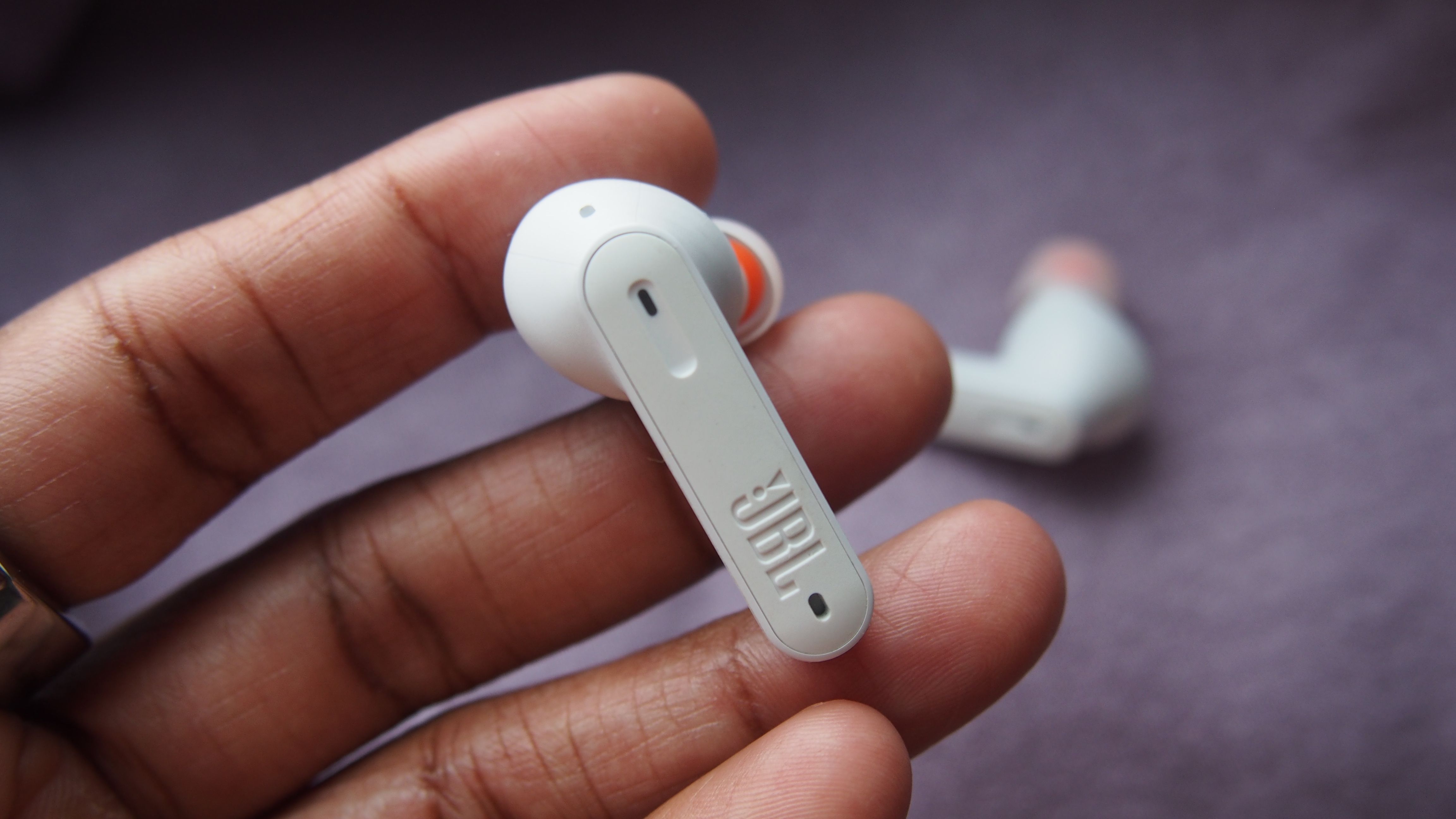 a closeup of one jbl tune 230nc earbud