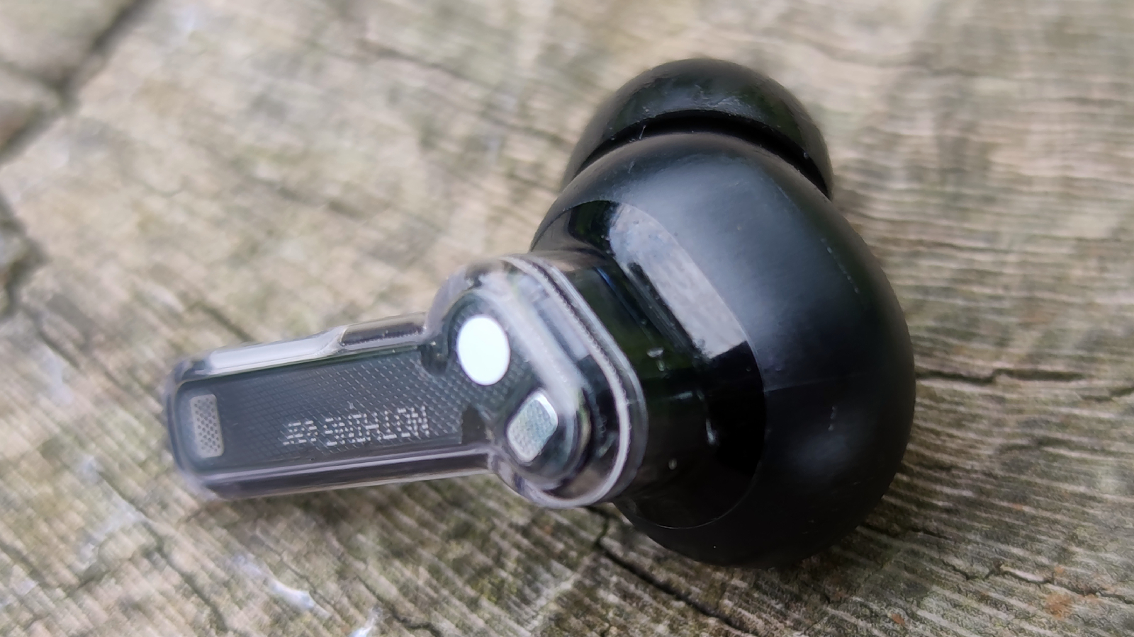 The Nothing Ear buds on a log.